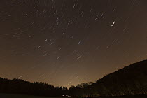 Star trails in winter above country road, Germany