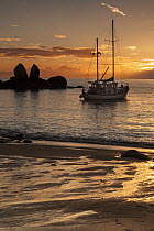 Sailboat anchored in bay at sunrise, Split Apple Rock, Abel Tasman National Park, South Island, New Zealand