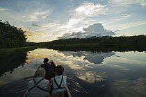 Toursist and birdwatchers in canoe, Amazon, Ecuador