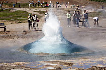 Tourists watching eruption of Strokkur Geyser, Iceland