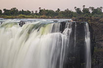 People swimming in pool at the top of falls, Victoria Falls, Zimbabwe