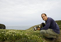 Sebastian Kennerknecht photographing on coast, Skomer Island National Nature Reserve, Skomer Island, Pembrokeshire, Wales, United Kingdom