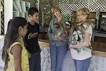 Brown-throated Three-toed Sloth (Bradypus variegatus) conservationist, Judy Avey-Arroyo, and biologist, Rebecca Cliffe, teaching local children about sloths, Aviarios Sloth Sanctuary, Costa Rica