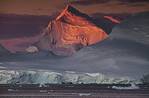 Alpenglow lighting up high peaks of Wiencke and Anvers Islands, near Port Lockroy, Antarctic Peninsula, Antarctica