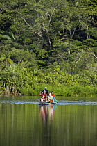 Tourists in canoe on river, Amazon, Ecuador
