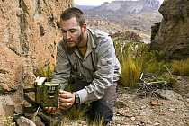 Andean Mountain Cat (Leopardus jacobita) biologist, Juan Reppucci, checking camera trap, Abra Granada, Andes, northwestern Argentina