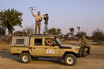 African Lion (Panthera leo) biologists, Luke Hunter, Kim Young-Overton, Jake Overton, and park scout, Timbo Frackson, tracking collared lioness, Kafue National Park, Zambia