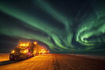 Northern lights over trucks on Dalton Highway which is used to service oil fields in Prudhoe Bay, Alaska