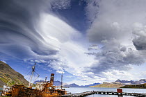 Lenticular cloud formations over old rusty whaling ships, Grytviken, South Georgia Island