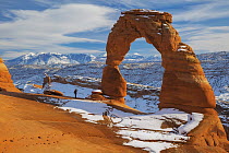 Hiker at Delicate Arch in winter, Arches National Park, Utah