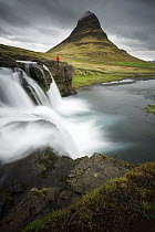Hiker at waterfall, Kirkjufellsfoss, Snaefellsnes Peninsula, Iceland