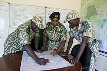 Park warden, Miriam Namushi, discussing anti-poaching strategies with her commanders, Kafue National Park, Zambia