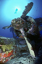 Scuba diver exploring World War II Japanese bi-plane wreck, New Britain, Papua New Guinea