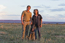 Domestic Dog (Canis familiaris), scent detection dog, with Cheetah (Acinonyx jubatus) conservationist, Laurie Marker, and staff member, Cheetah Conservation Fund, Namibia