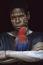 Aboriginal woman with a female Eclectus Parrot (Eclectus roratus), Karowari River, Papua New Guinea