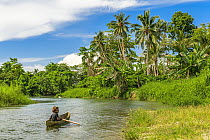 Woman paddling dug-out canoe, Mbonegi River, Guadalcanal, Solomon Islands