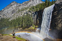 Hiker near waterfall and rainbow, Nevada Fall, Yosemite National Park, California