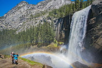 Hikers near waterfall and rainbow, Nevada Fall, Yosemite National Park, California