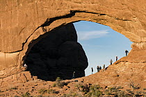 Large number of tourists on overcrowded hiking trail under North Window Arch, Arches National Park, Utah