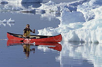 Female canoeist on Hudson Bay among pack ice, Churchill, Manitoba, Canada
