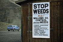 Weed control signage along Highway 82, Wallowa County, listing introduced plants that have become invasive weeds, Oregon