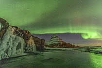 Northern lights over frozen waterfall and mountain, Grundarfjordur, Iceland