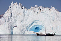 Schooner in front of large iceberg, Scoresby Sound, Greenland