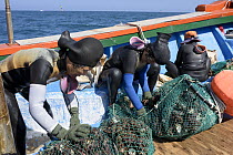 Haenyeo, traditional fishing divers, with catch, Jeju Island, South Korea