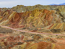 Road going through eroded hills of sedimentary conglomerate and sandstone, Zhangye National Geopark, China