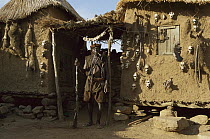 Dogon hunter in front of his hut showing various primate skulls, Sahel Desert, Mali, west Africa