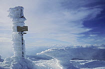 Ice accumulated on the side of a sign post on the summit of Pico Puigmal, Pyrenees, Spain