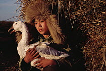 Domestic Goose held by child, China