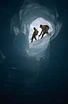 Ice climbers seen through ice cave, Columbia Icefield, Jasper National Park, Alberta, Canada