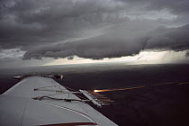 Cloud seeding equipment on wing of plane viewed through window flying over North Dakota