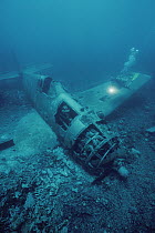 Diver Meredith Eder exploring wreck of a WWII Corsair aircraft, Solomon Islands