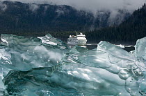 Cruise ship behind blue iceberg, southeast Alaska