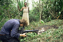 Cameraman Martin Dohrn filming sow birth watched by local woman, Papua New Guinea, for tv series "Lifesense"