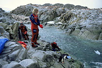 Peter Scoones, Martha Holmes and Adelie Penguin preparing to dive, Antarctica  - on location for Life in the Freezer, 1992