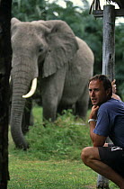 Martyn Colbeck on location at Amboseli Elephant Research Camp, Kenya, with elephants in the background. On location for BBC television programme "Echo of the Elephants: The next Generation" filmed 199...