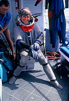 Presenter Mike De Gruy preparing to dive in shark suit off California, USA,  filming for BBC NHU  series Seatrek 1991