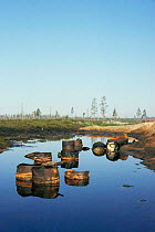 Oil barrels dumped in polluted lake, Siberia.