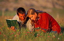 Man and woman botanising. Coll, Argyll, Scotland. Using magnifying glass and books