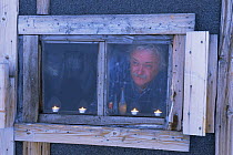 Camerman Martin Saunders, looking out of the Texas Bar hut, home for film crew on location for Polar Bear programme, Svalbard, Norway. 1996