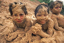 Maydruna Indian children covered in mud. Amazon Basin, Peru. Tropical rain-forest.