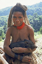 Hagahai woman with pig, Papua New Guinea.  Captured piglets are reared like children, and are a symbol of wealth