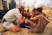 Dr Philip Sander and Ju / Hoan bushmen, replacing leopard tracking collar, Bushmanland, Namibia. 1996