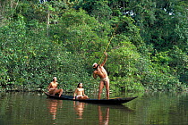 Matses indians hunting from canoe in rainforest, Peru. Amazonia Model released.
