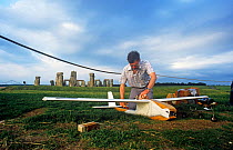 Clive Hall preparing glider painted to look like a stork for remote control aerial filming for 'In-Flight Movie', with Stonehenge in background, Wiltshire, England, UK, 1986