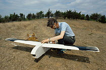 Clive Hall preparing glider painted to look like a stork for remote control aerial filming for 'In-Flight Movie', England, UK, 1986