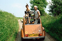 Alan Hayward (right) and Nigel Marven standing in back of a stationary filming car, having a break from filming an imprinted Common starling (Sturnus vulgaris)  for 'In-Flight Movie', England, UK, 198...